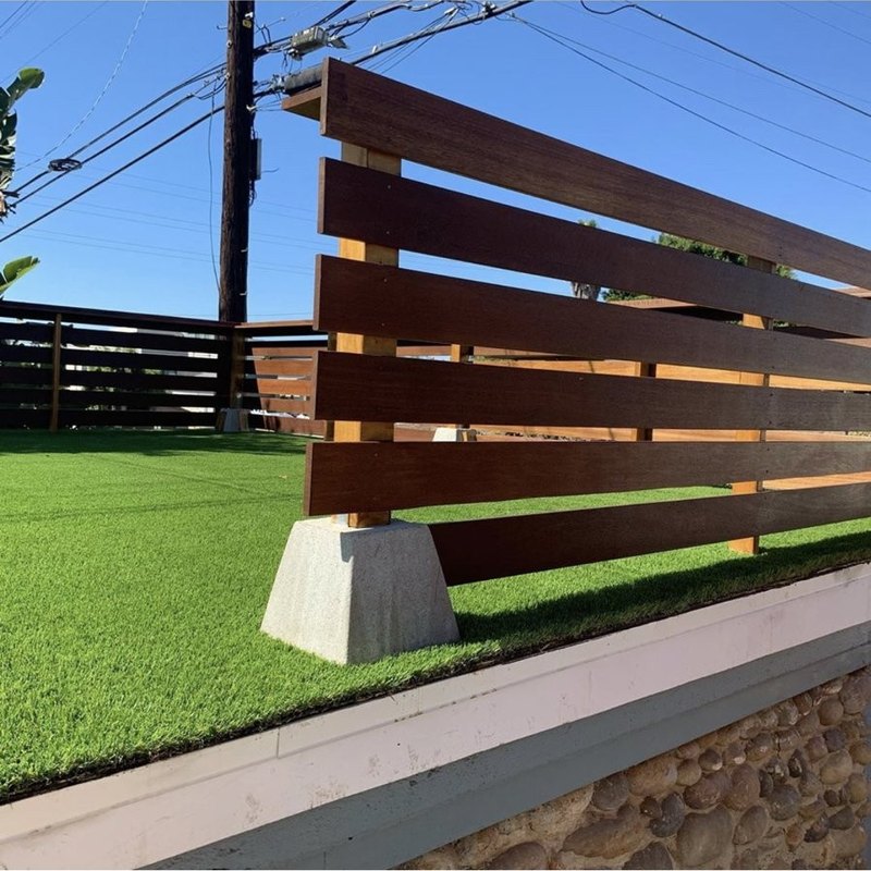Modern horizontal wood slat fence on a block wall by Fence Tech