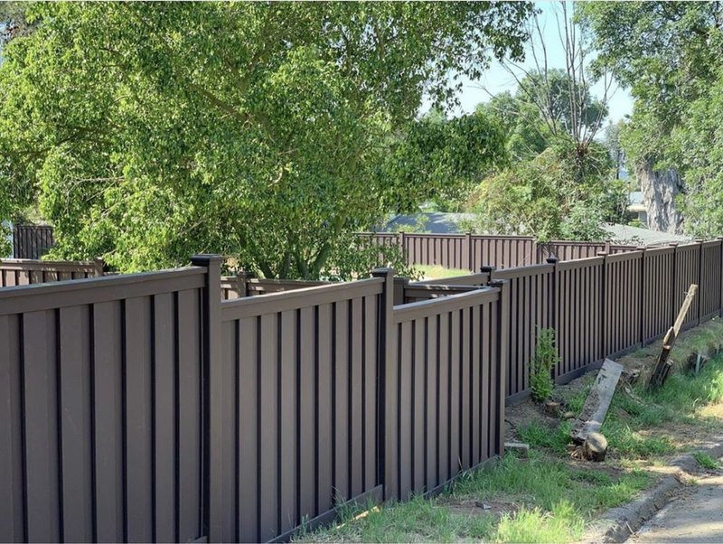 Dark stained wood board fence line installed by Fence Tech